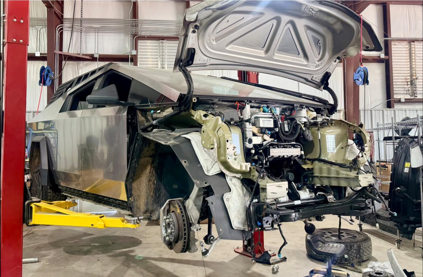 Before — Tesla Cybertruck front-end collision repair in progress on frame rack